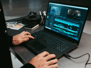 person working on a laptop with a video editor open