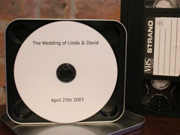 VHS tape next to a custom made DVD of a family wedding
